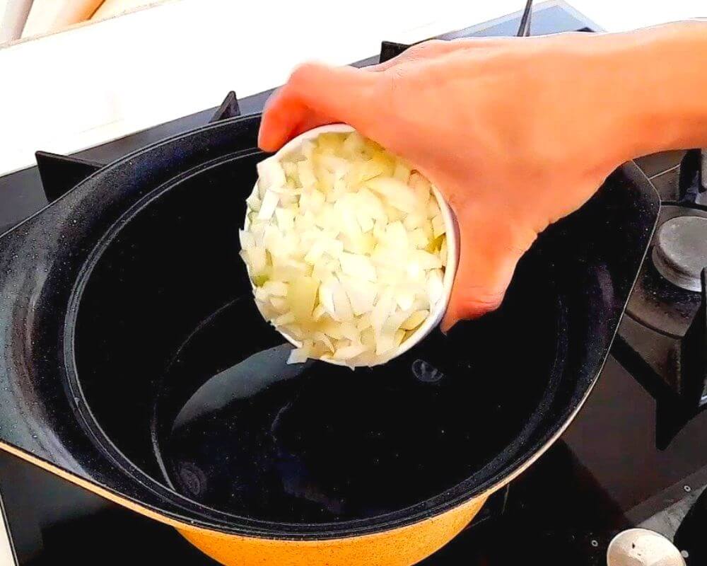 Start by pouring oil into a pot and adding the onions. Fry the onions until they become slightly golden.
