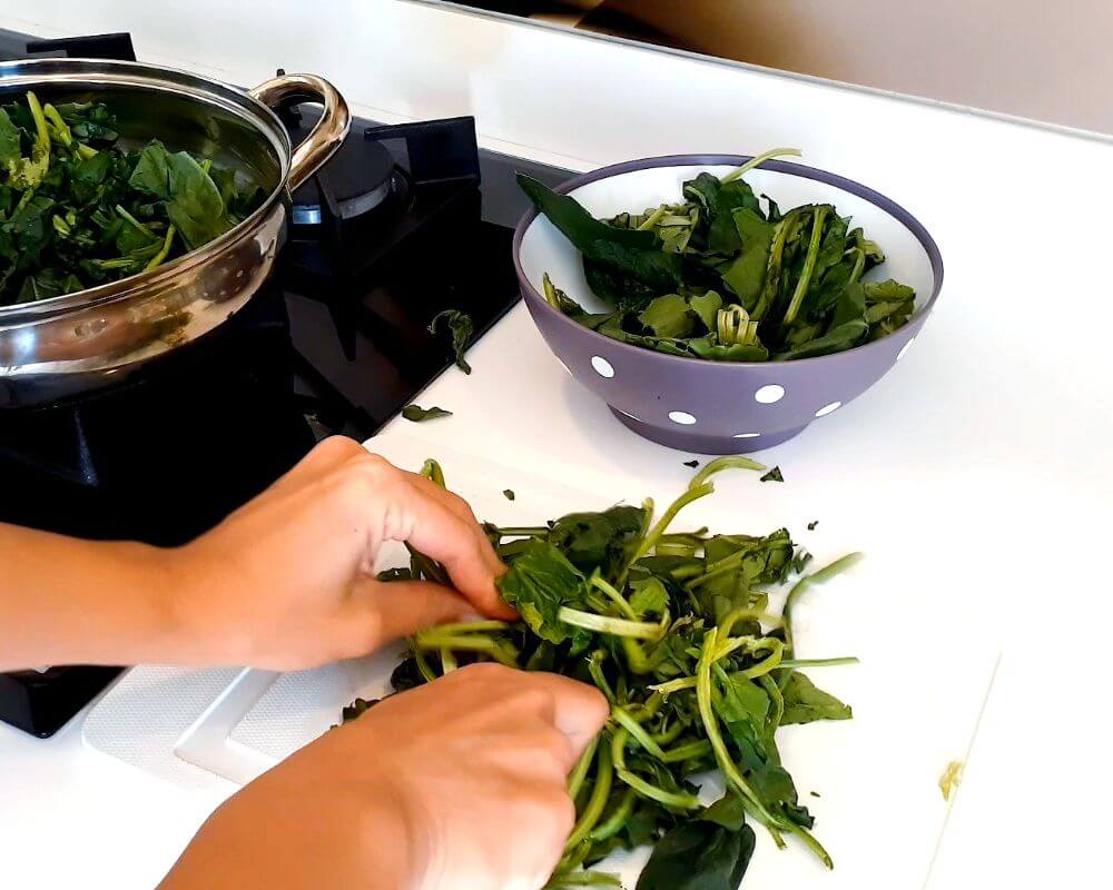 Wash the fresh spinach and chop it finely, and let it cook until the spinach juice is extracted.
