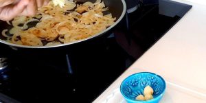Then, chop the onion finely and fry it in a pan with some oil until it becomes soft and translucent.